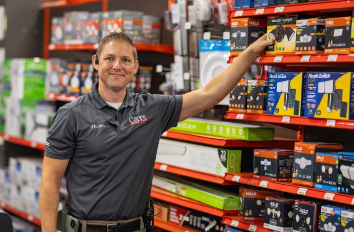 Capps employee standing in the electrical and plumbing products aisle