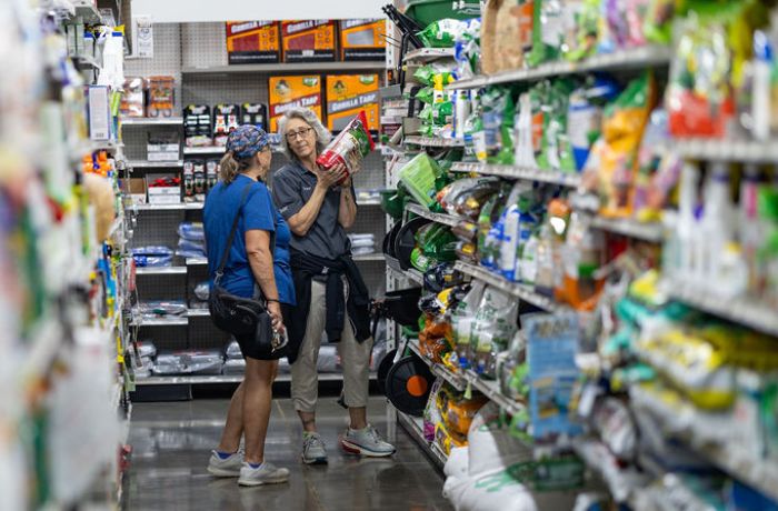 Capps employee helping a customer in the lawn and garden product aisle